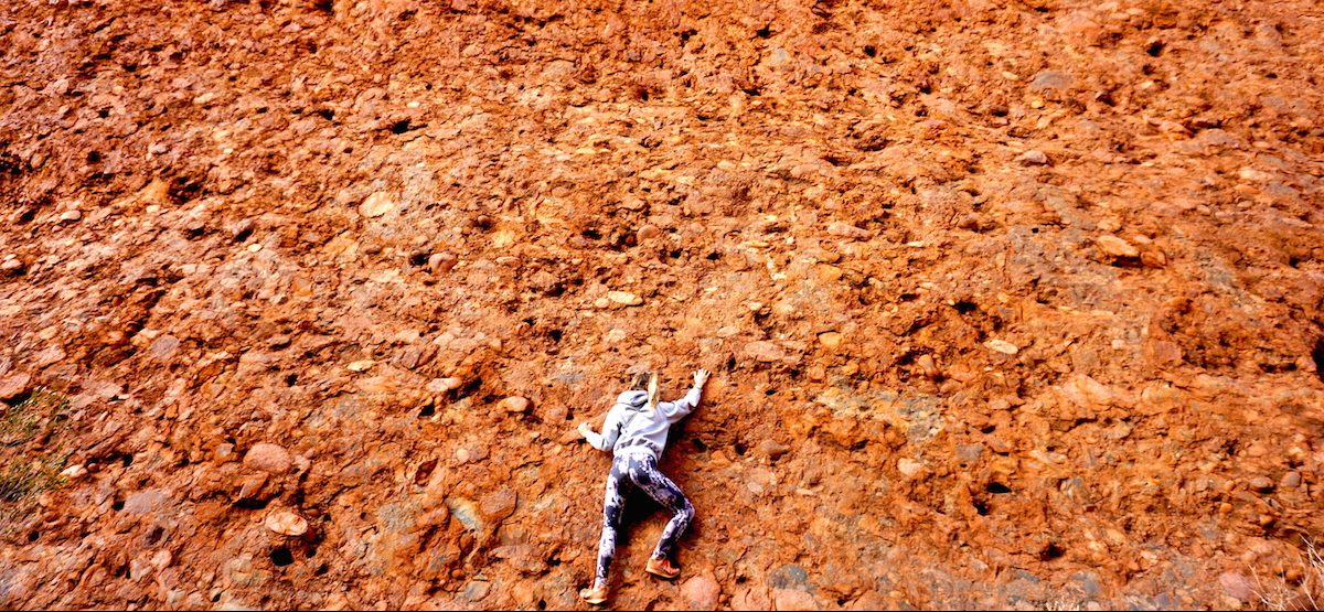 Julia kletternd an roter Felswand bei den Kata Tjutas
